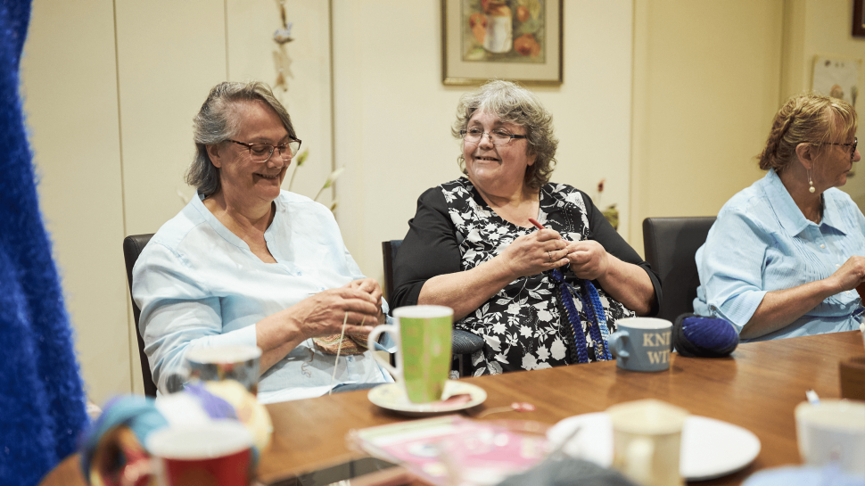 Two women smiling over breakfast