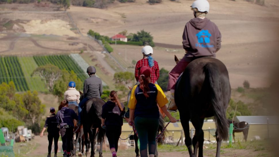 West Moonah Community House horse riding. Rural landscape in background.